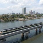 Train électrique moderne franchissant la lagune à Abidjan, illustration de la mobilité urbaine durable.